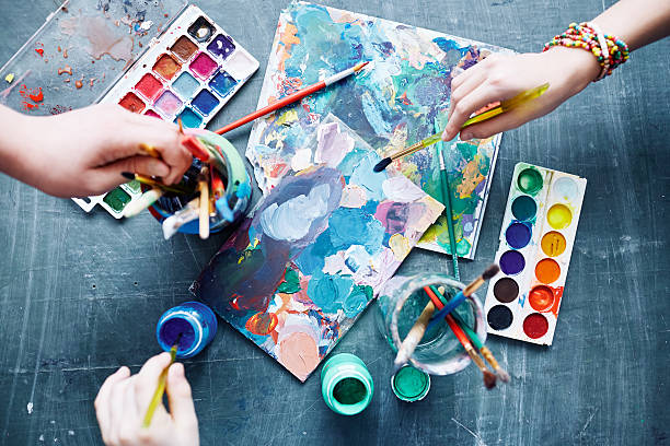Children with paintbrushes beginning to create